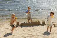 Boys Playing with Water Guns on a Sunny Beach