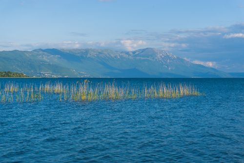 Free Tranquil scene of Ohrid Lake with distant mountains and clear blue skies, capturing nature's beauty. Stock Photo