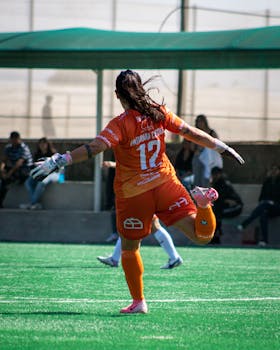 A female goalkeeper in action during a soccer match in Chile, showcasing athleticism and focus.
