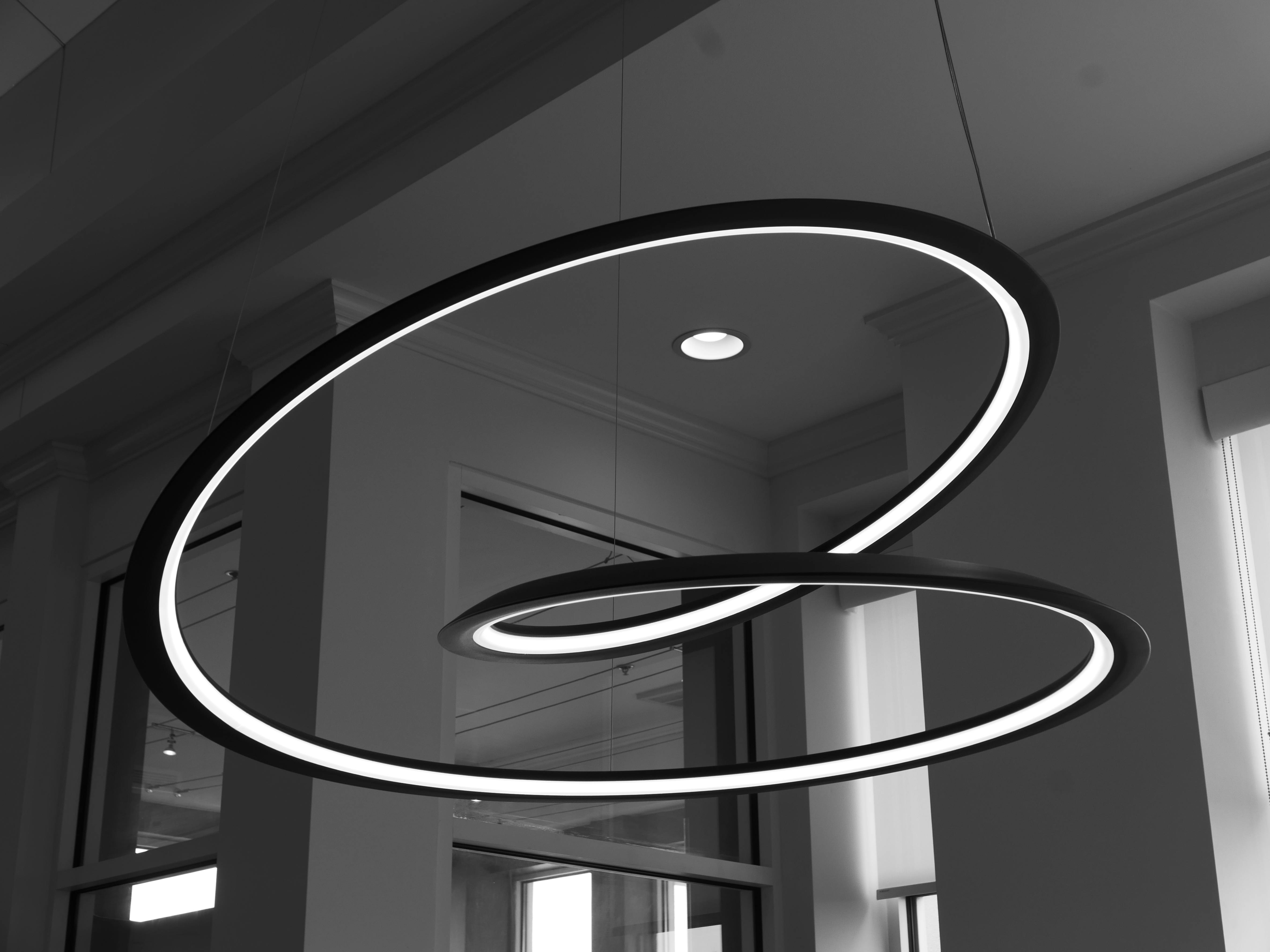 Black and white photo of abstract circular LED ceiling light with reflections.