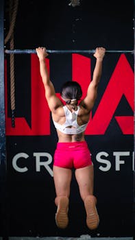 Fit woman executing a pull-up during a CrossFit workout at a gym in San Luis Potosí, Mexico.