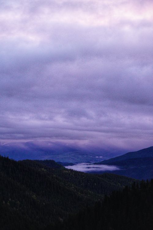 Free Majestic mountain landscape under a dramatic purple twilight sky. Stock Photo