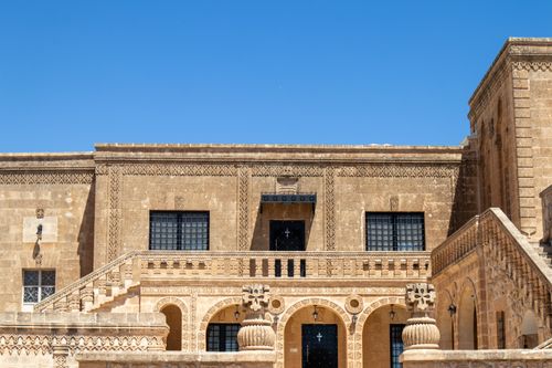 Free Explore the intricate stone architecture of a historic building in Mardin, Türkiye, under a clear blue sky. Stock Photo