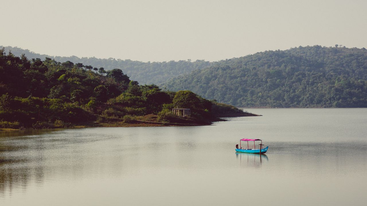 peaceful landscape with a boat on a tranquil lake surrounded by hills