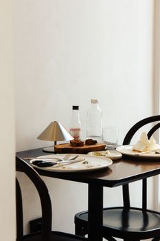 Chic dining setup in a minimalist cafe with empty plates and ambient lighting.