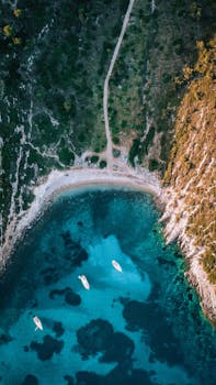Aerial drone shot capturing the stunning blue waters and natural beauty of a secluded cove in Urla, Izmir, Turkey.