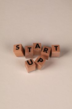 Wooden blocks spelling 'START UP' on a neutral background, symbolizing new beginnings.