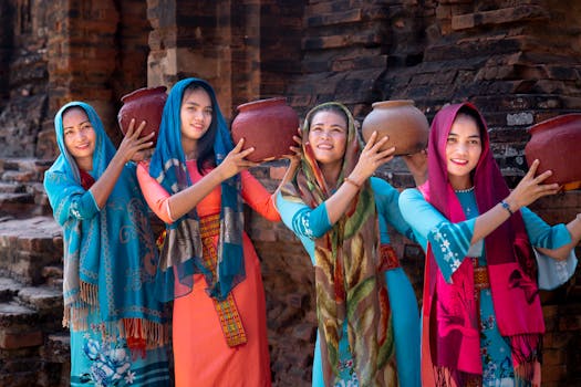 四名身着鲜艳传统服装的女性手持陶罐，展示着文化遗产