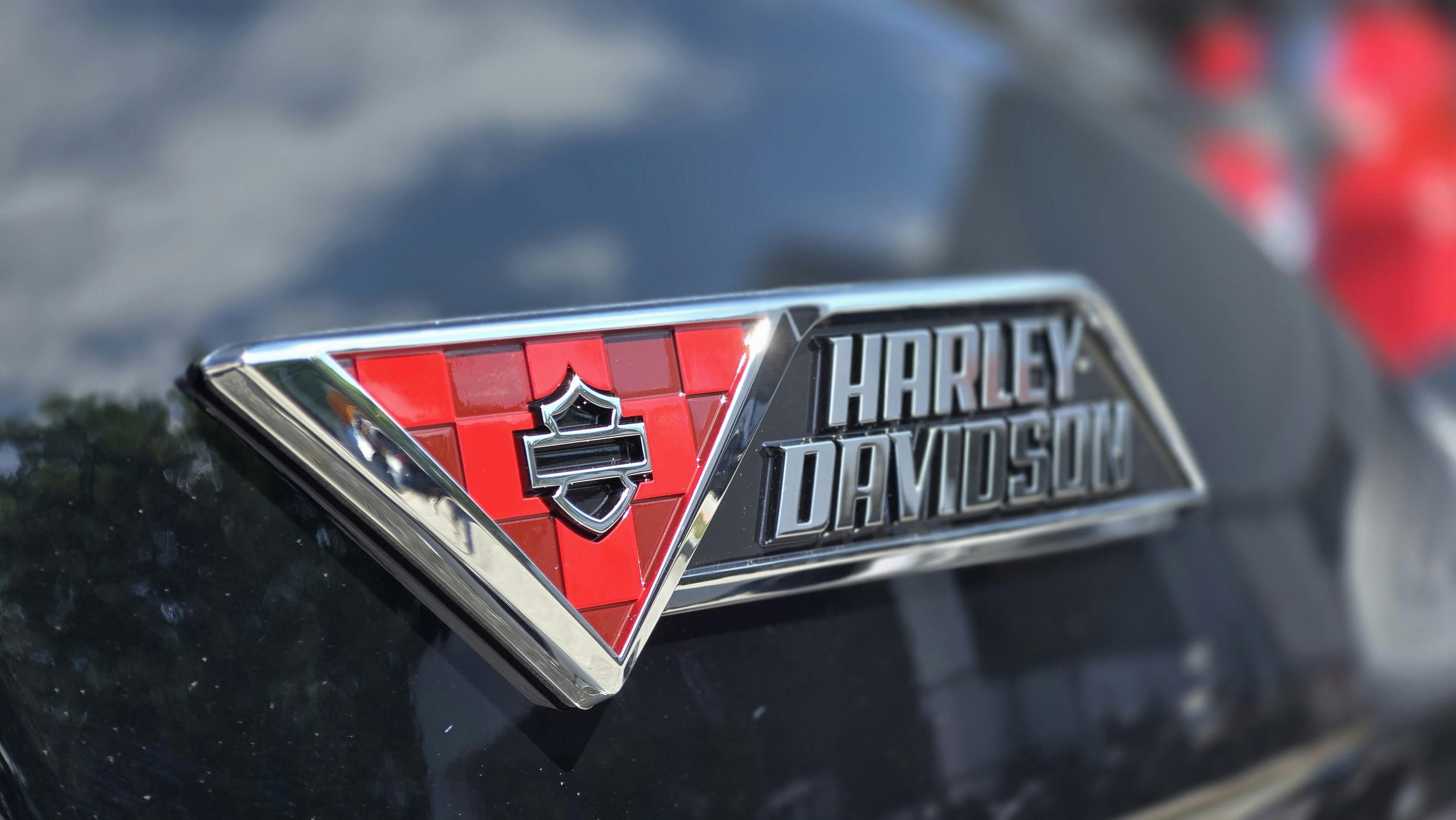 Sharp close-up of a Harley-Davidson motorcycle emblem, featuring bold red and black design.