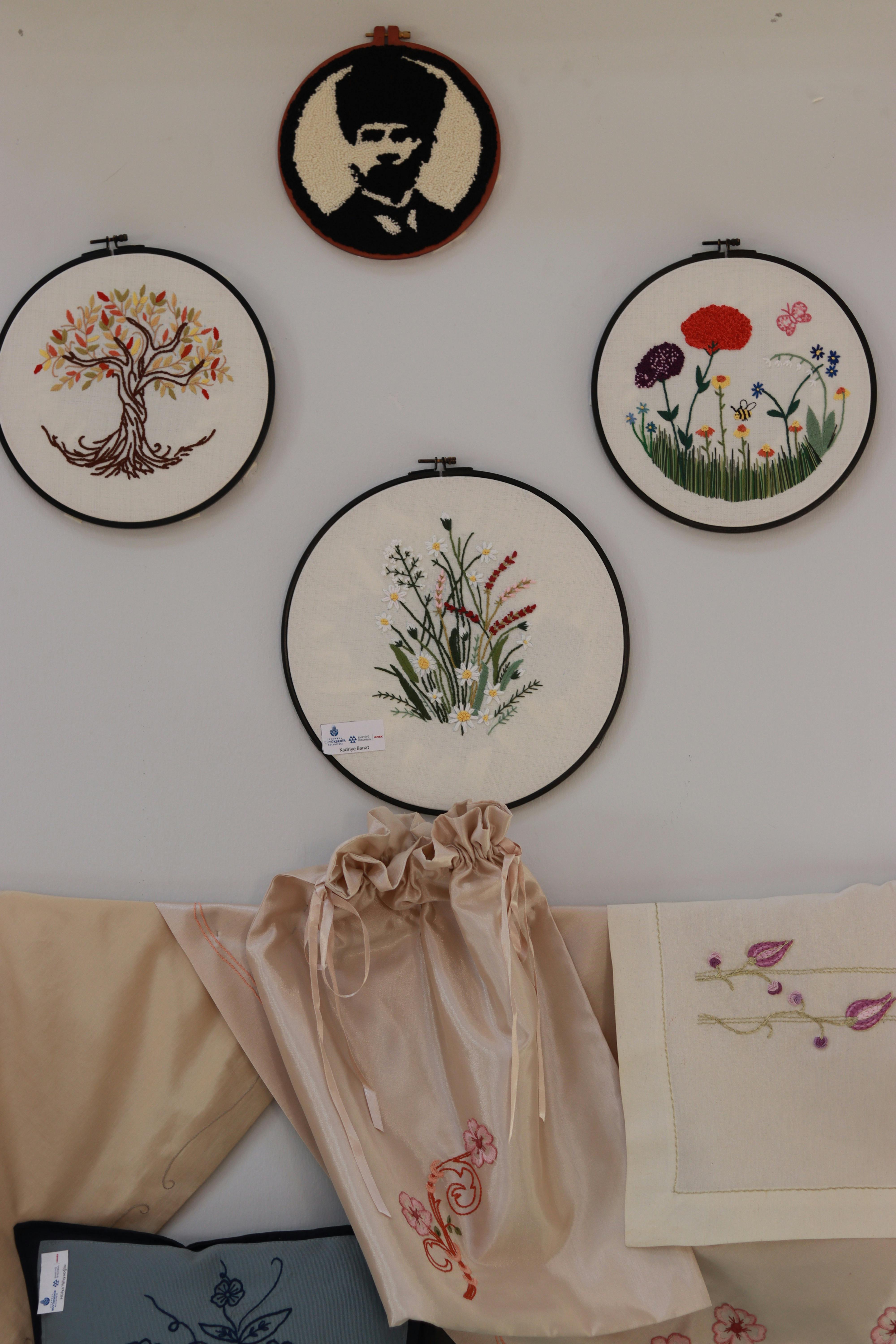 Handcrafted embroidery circles on wall with floral and artistic designs.