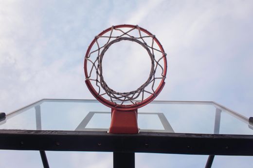 A basketball hoop shot from below against open sky — photo by umar muazu on Pexels