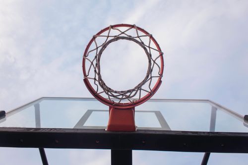 Free A basketball hoop shot from below against a clear blue sky, ideal for sports themes. Stock Photo