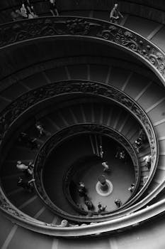 Black and white aerial view of the intricate spiral staircase in Vatican Museum.