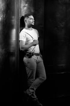 Stylish monochrome portrait of a man leaning against a wall in Buenos Aires.