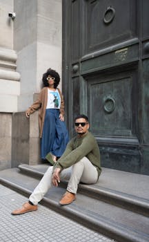 Two stylish adults posing on historical steps in Buenos Aires, Argentina.