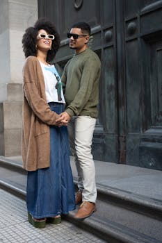 A fashionable couple poses in Buenos Aires, showcasing modern casual style outdoors.