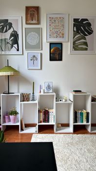 Modern home interior featuring a stylish bookshelf with art prints and decor in Barcelona, Spain.