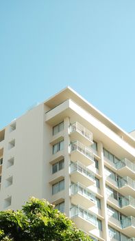 Minimalist view of a modern apartment building with a clear blue sky.