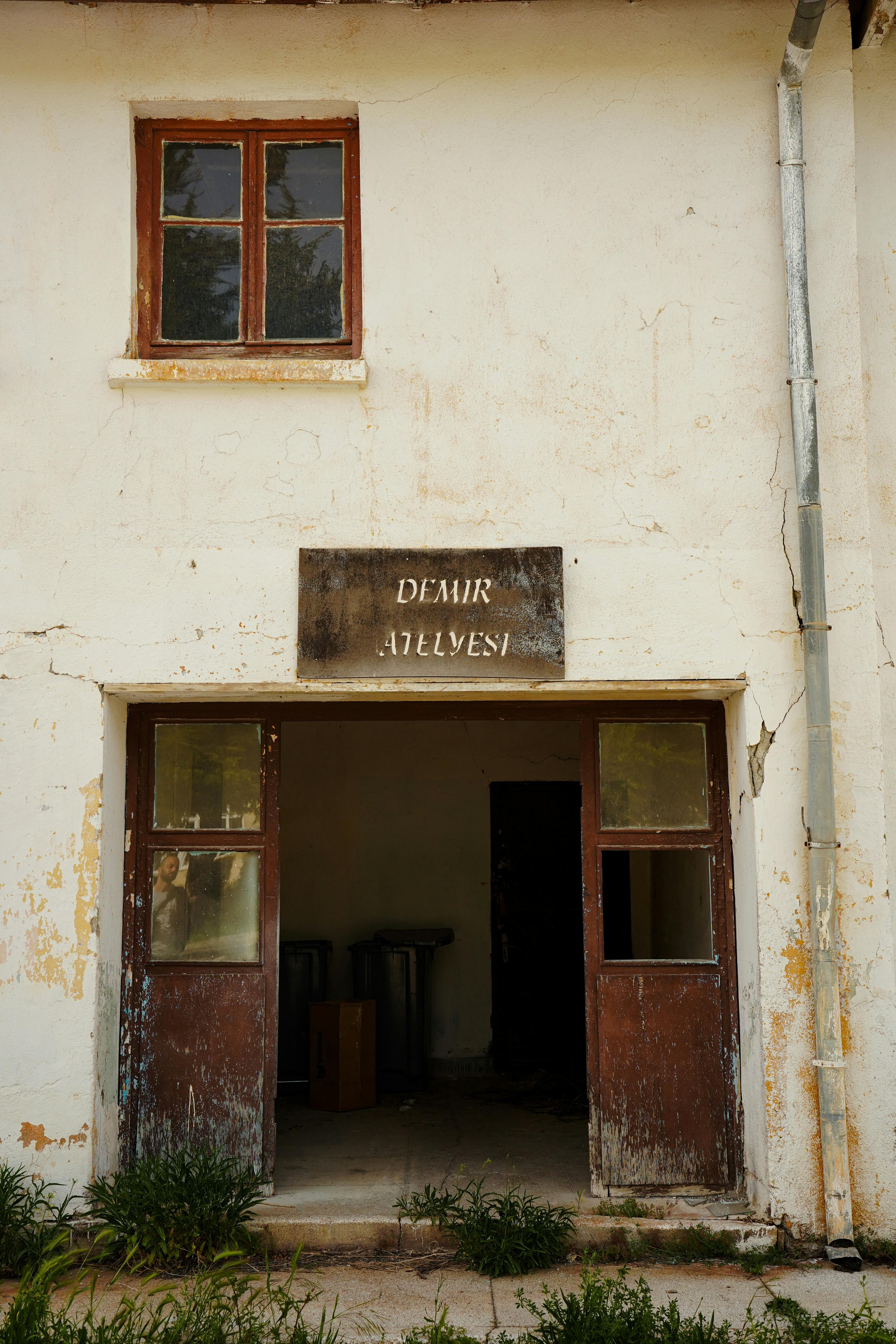 Weathered facade of a historic workshop with open doors in Ankara, Türkiye.
