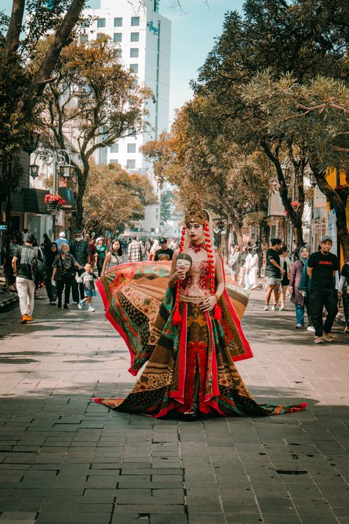 Free A traditional Indonesian dancer in vibrant attire performs on Braga Street, Bandung. Stock Photo