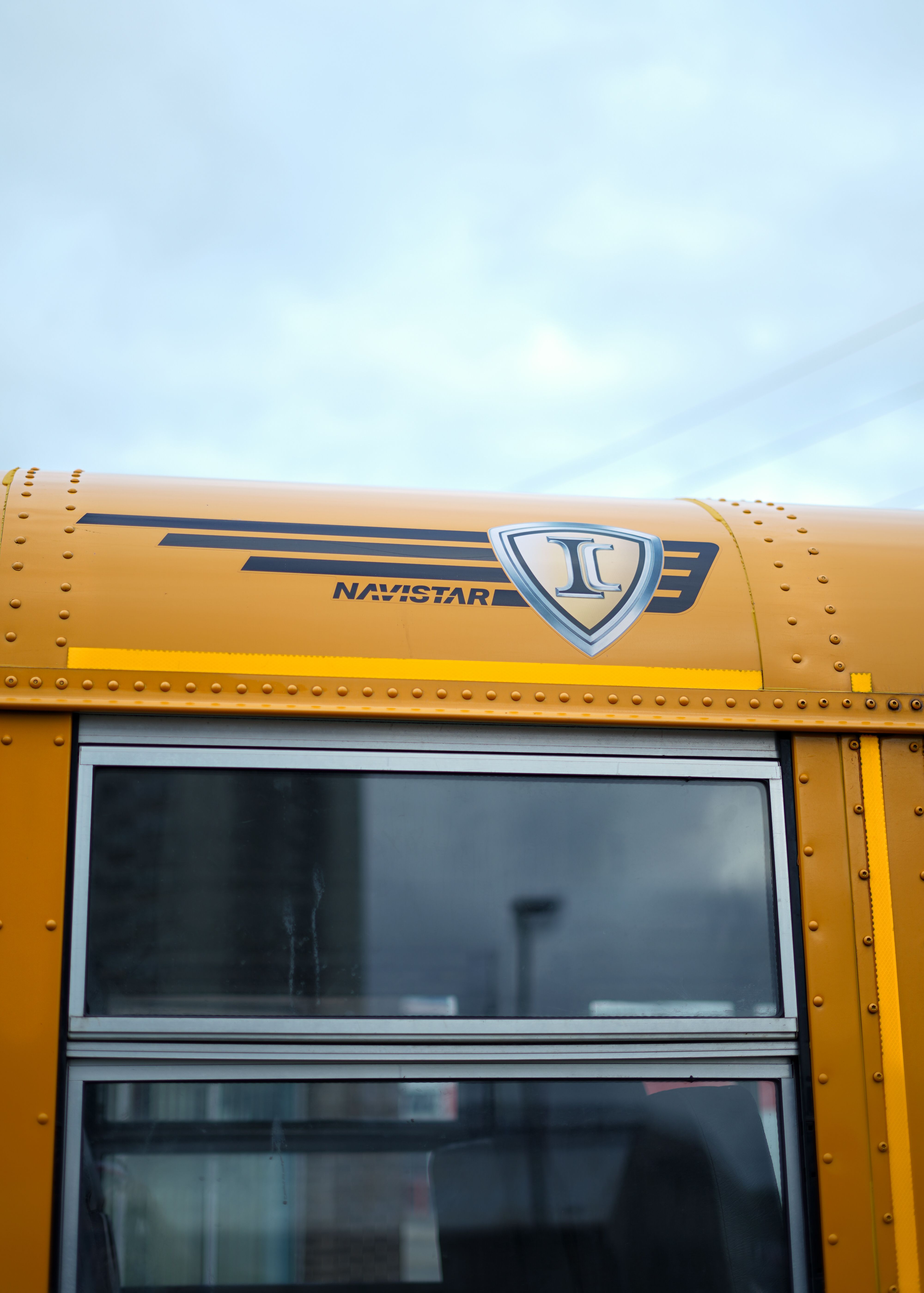 Detailed image of a yellow Navistar school bus in Kitchener, Ontario, highlighting its window and logo.