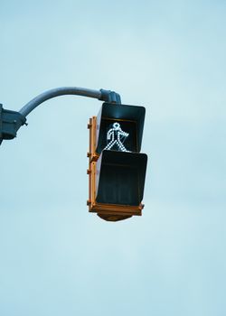 Pedestrian crossing signal indicating walk on a clear day in Kitchener, Ontario.