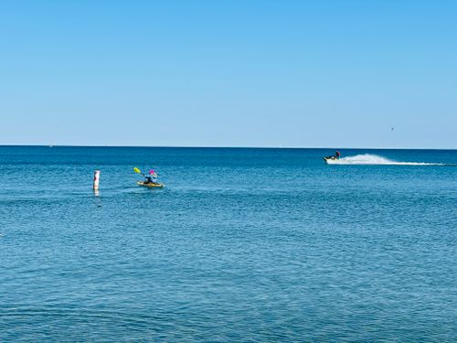 Free A jet skier and kayaker enjoy the open sea under a clear blue sky. Stock Photo