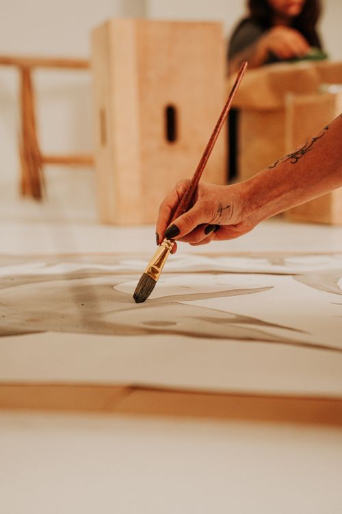 Free Close-up of an artist painting abstract art on canvas inside a studio space. Stock Photo