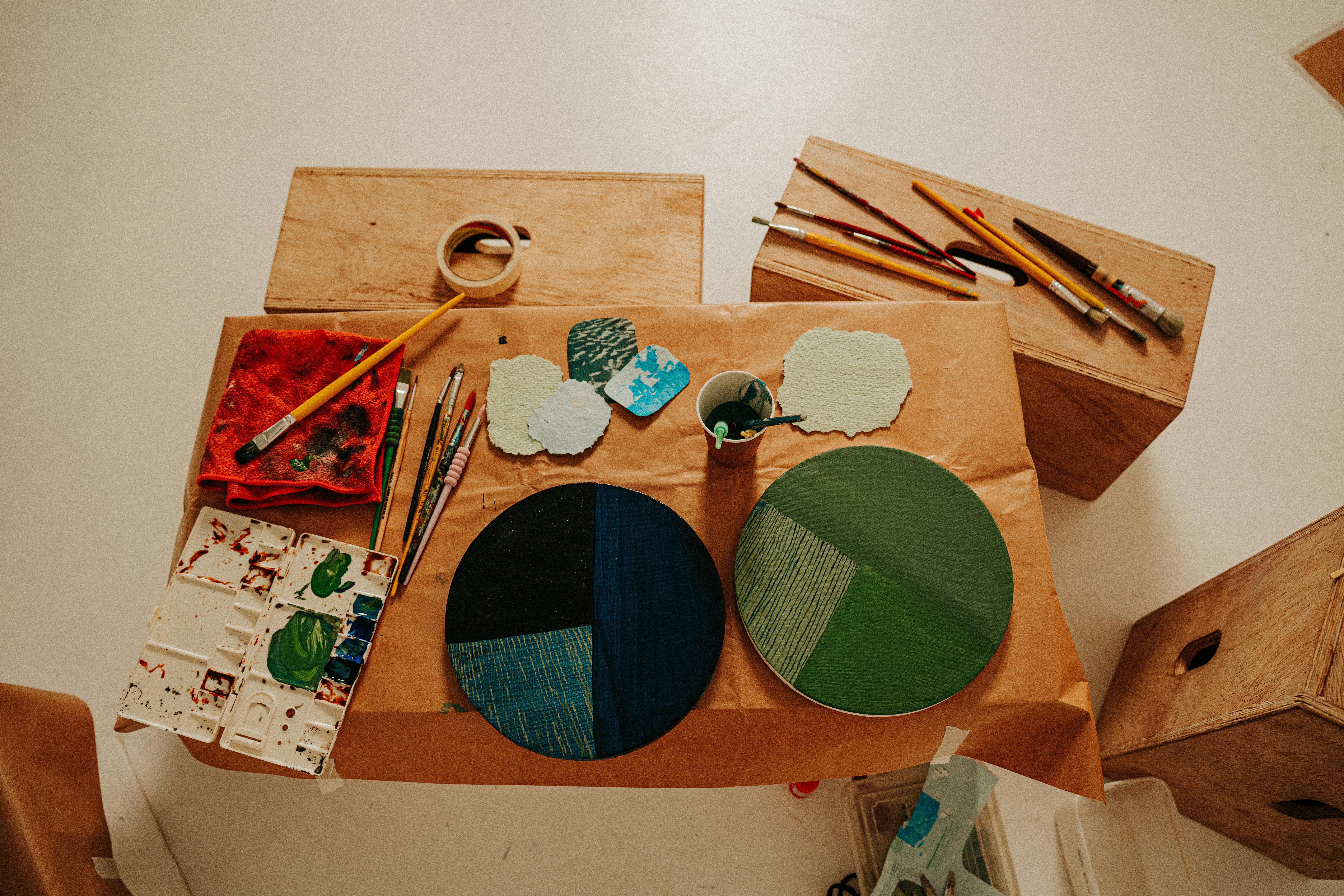 Artistic arrangement of painting tools and palettes on wooden boxes for creative inspiration.