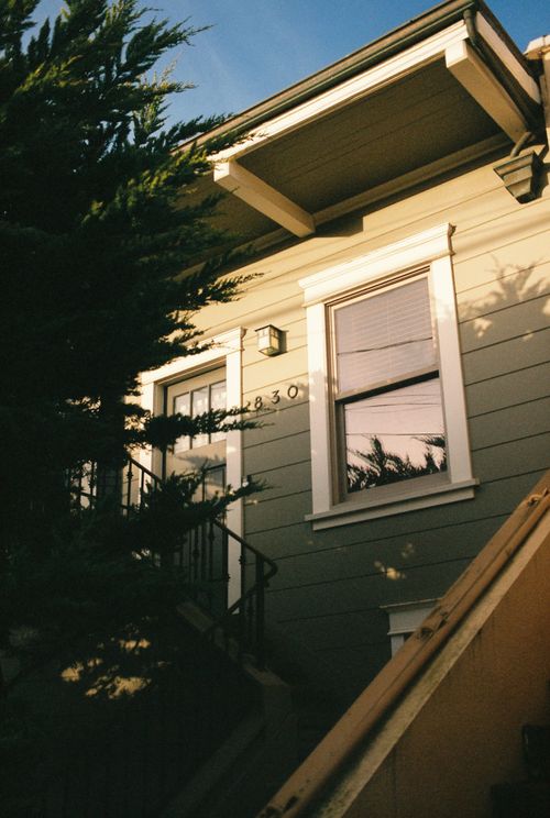 Free Exterior of a quaint suburban house captured beautifully at sunset, with warm lighting and shadows. Stock Photo