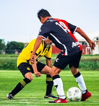 Two adult men playing soccer in an intense outdoor match in Puebla, Mexico.