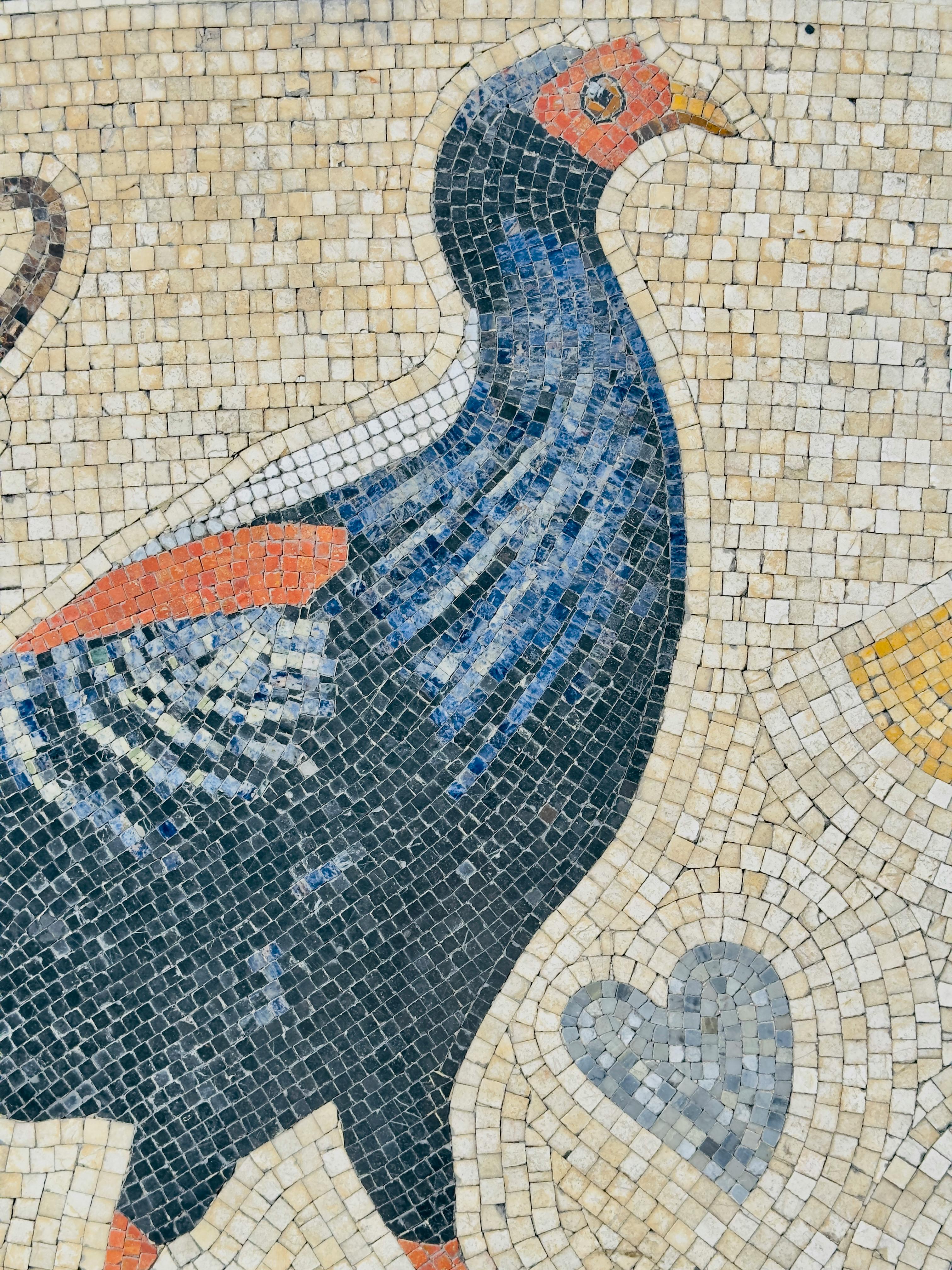 Vibrant mosaic depicting a stylized bird on a textured wall background.