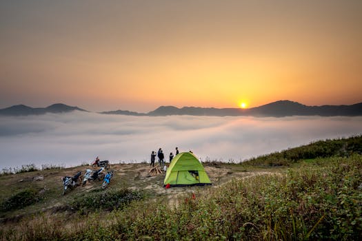 拍摄日出时宁静的露营场景，俯瞰云雾缭绕的山脉海洋