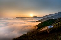 俯瞰山脉和云层，日出景色令人惊叹，展现出宁静的自然美景