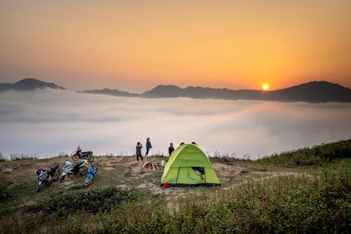 Free People Standing Near Camping Tent Overlooking Sea of Clouds during Golden Hour Stock Photo