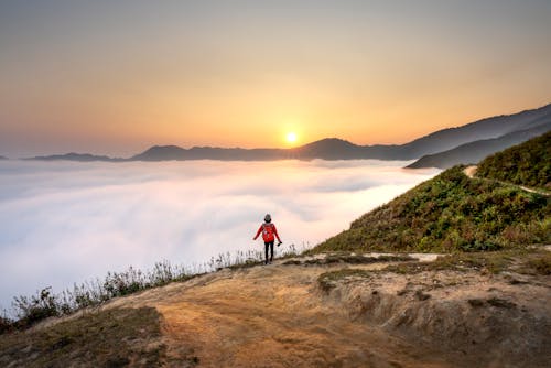 Free Person Standing Overlooking Sea of Clouds Stock Photo