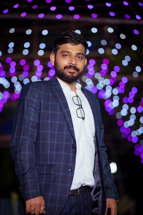 Free Formal portrait of a man in a suit with bokeh lights in the background. Stock Photo