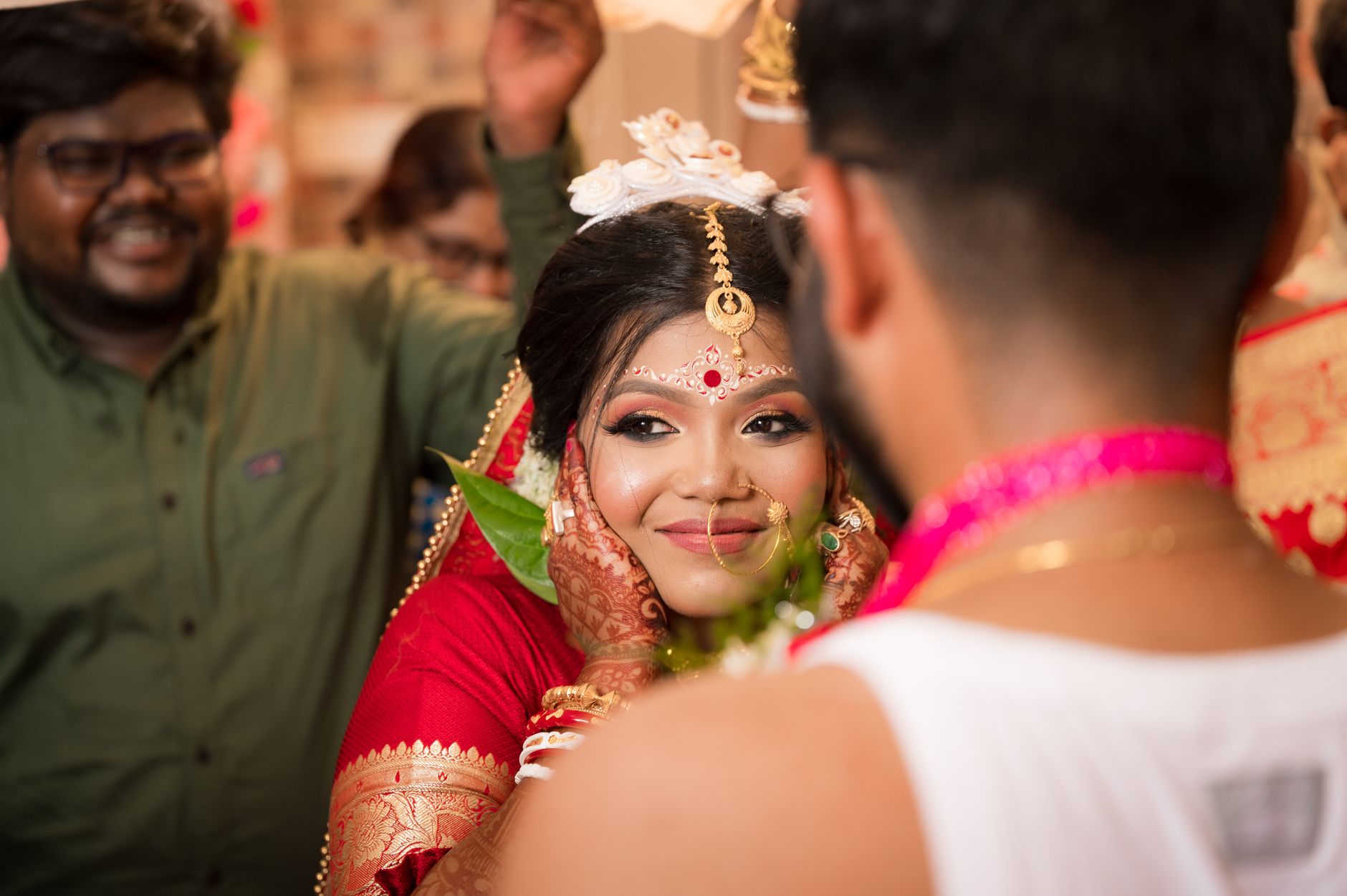 A joyful candid moment capturing a bride during a traditional Indian wedding ceremony.
