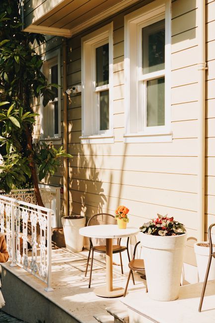 Charming outdoor patio with table, chairs, and plants in the warm sunlight.