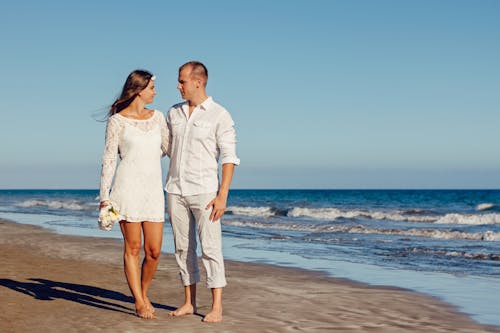 Free Man and Woman Standing Beside Each Other on Seashore Stock Photo