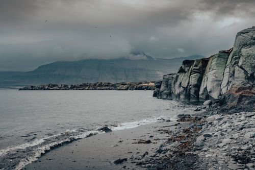 Free Stunning Icelandic cliffside view with rugged coastlines and a moody sky. Stock Photo