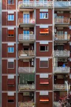 Close-up view of a modern apartment building facade featuring multiple balconies and diverse window styles.