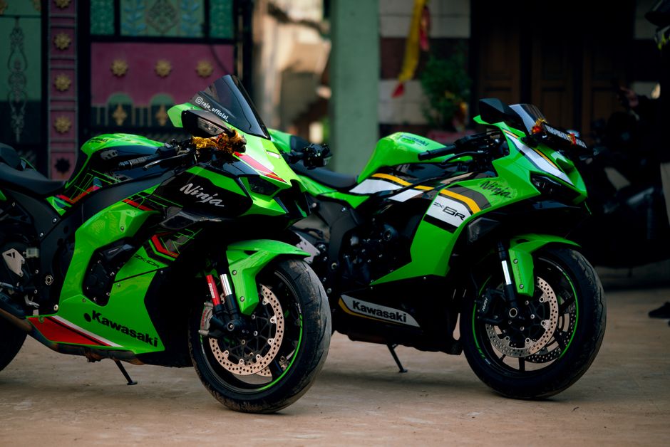 Two vibrant green Kawasaki Ninja motorcycles parked outdoors in OD, India.
