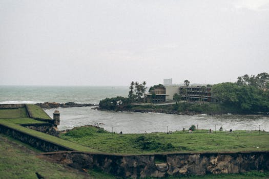 A tranquil view of Galle Fort with lush greenery and ocean backdrop in Sri Lanka.