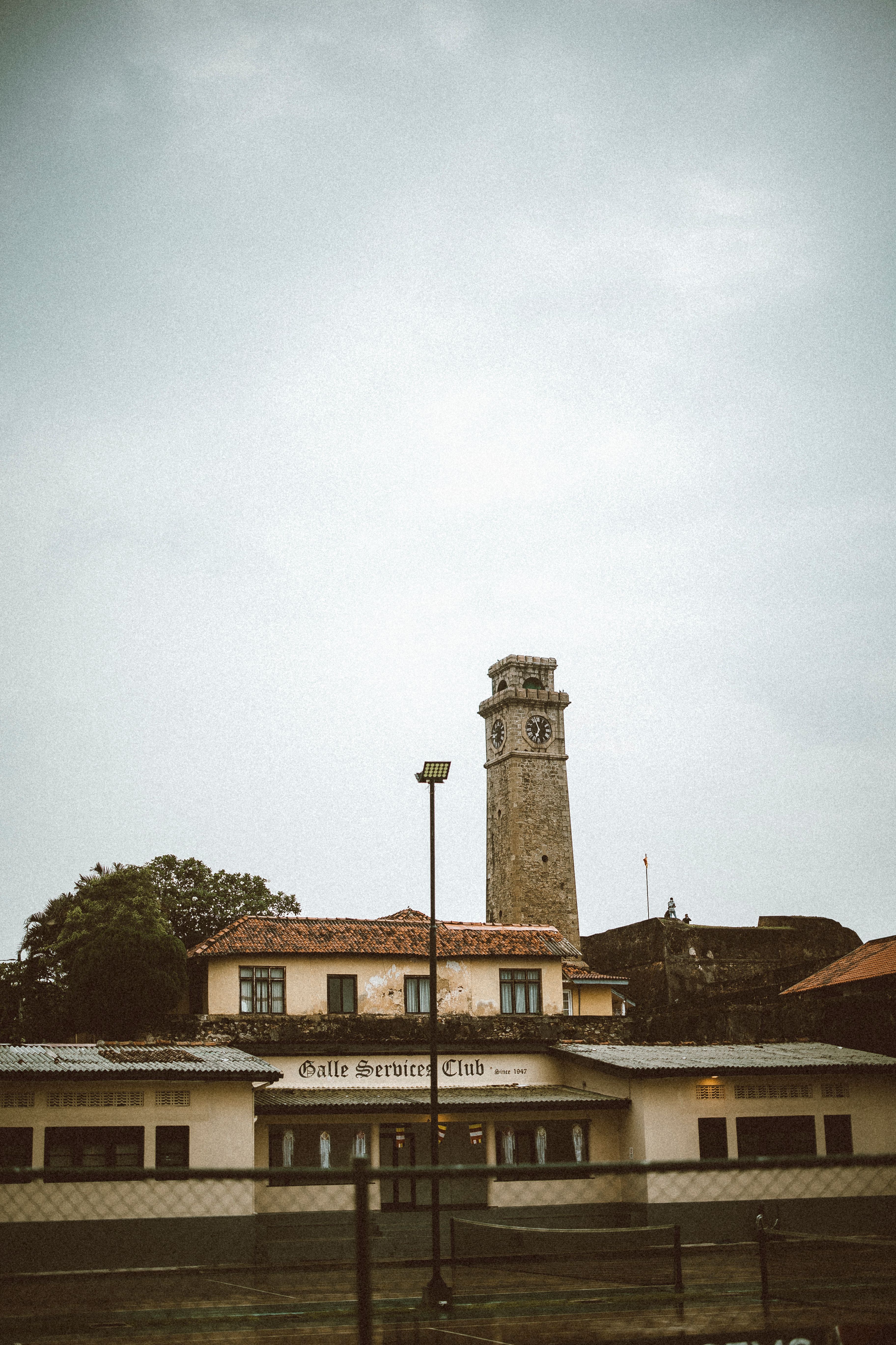Galle Fort's iconic clock tower stands tall under a cloudy sky in Sri Lanka.