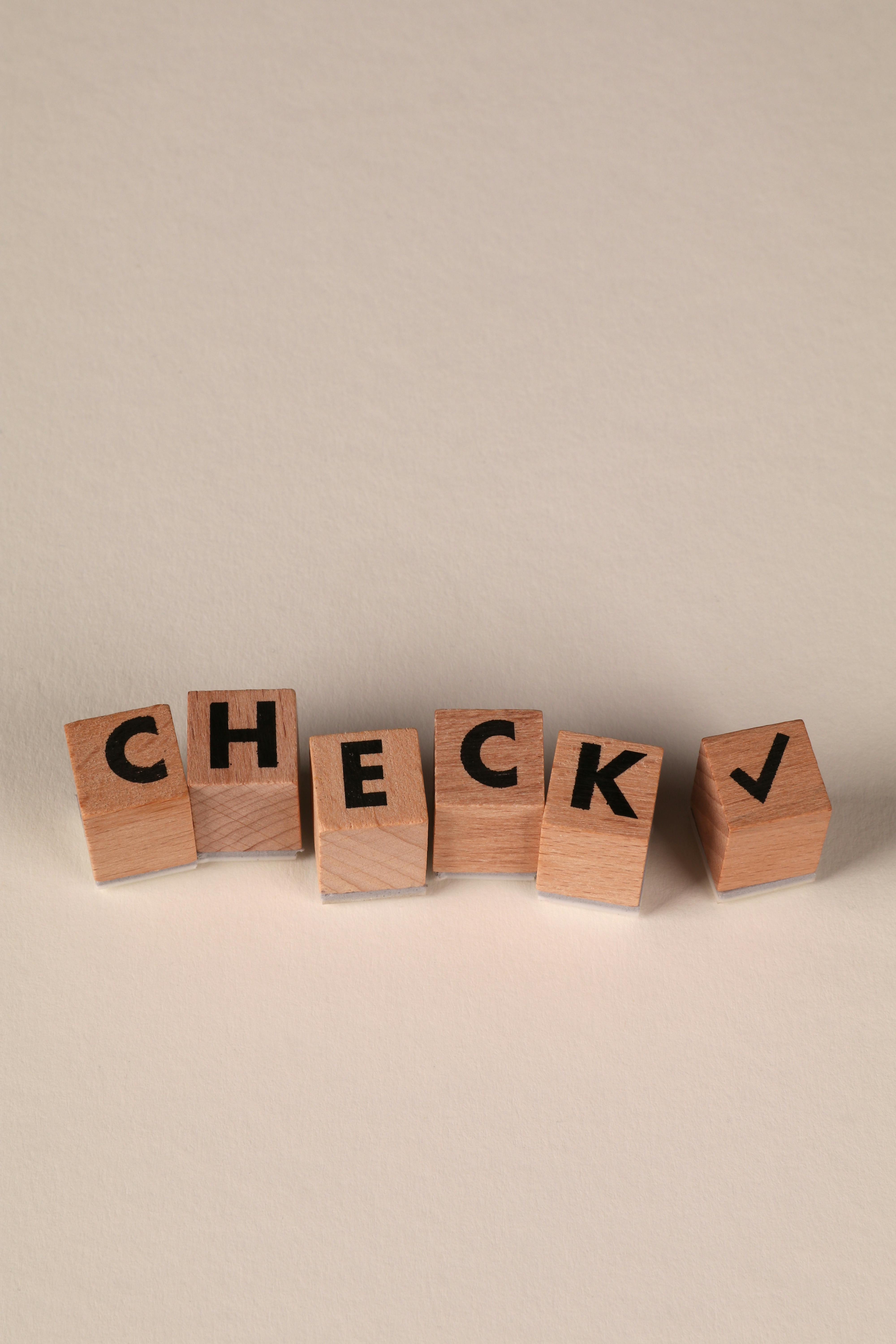 Kostenlos Holzbuchstabenblöcke mit der Aufschrift „CHECK“ und einem Häkchen im minimalistischen Stil. Stock-Foto