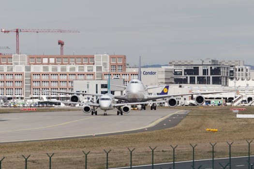 Airplanes at Frankfurt Airport wait on the runway amidst busy terminal activity.
