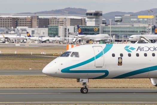 Air Dolomiti aircraft on taxiway with Frankfurt skyline in background.
