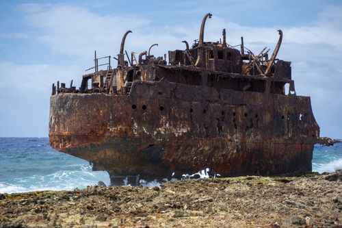 Free A dramatic view of a rusted shipwreck on the coast of Curaçao, perfect for adventure themes. Stock Photo