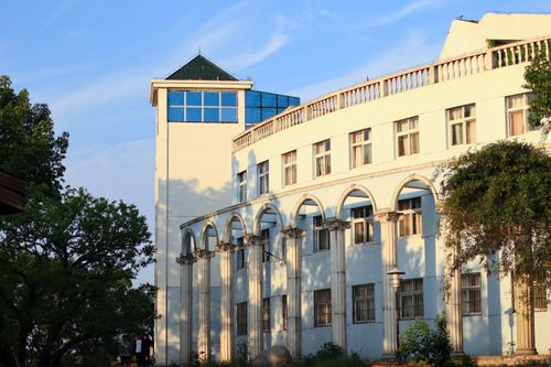 Free A white building with arched windows and columns under a clear blue sky. Stock Photo
